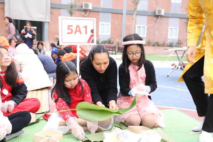 Học sinh Hà thành thích thú lần đầu trải nghiệm gói bánh chưng, làm mâm cơm Tất niên - 4