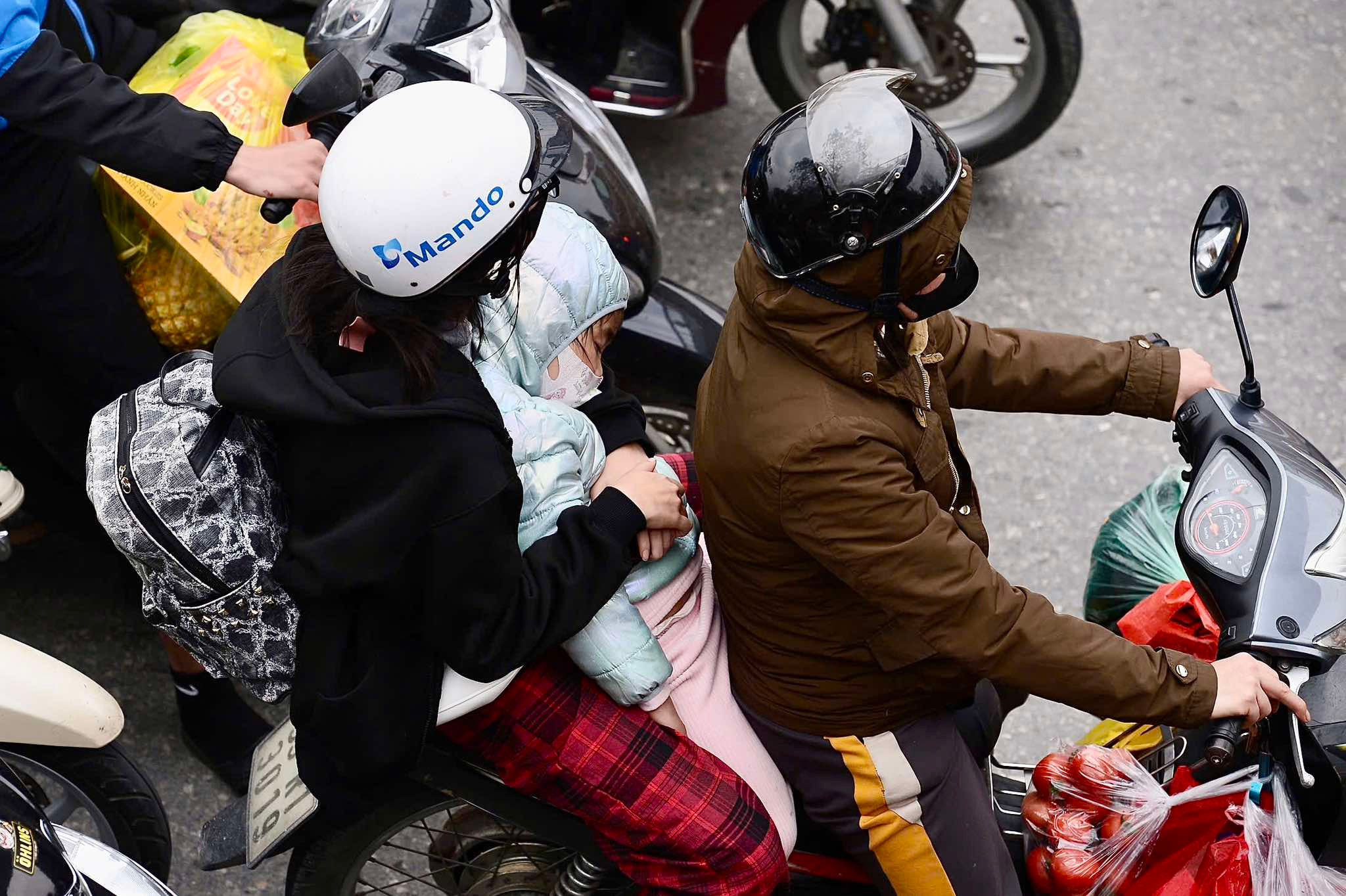 Kết thúc kỳ nghỉ Tết, trẻ em ngủ gục trên lưng bố mẹ trở lại Thủ đô