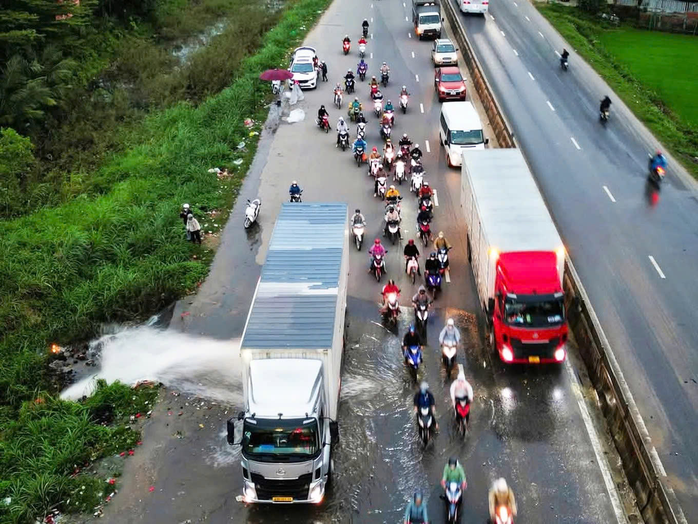 Dừng container chắn dòng nước cho xe máy chạy qua, tài xế nhận 'mưa' lời khen