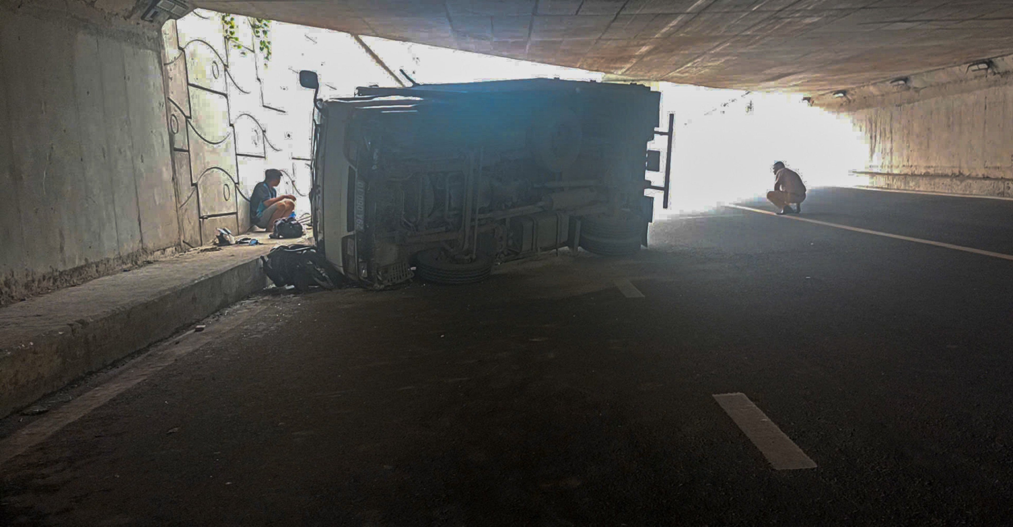 Xe tải biển xanh lật đè 2 xe máy ở cửa ngõ TP.HCM, 2 người bị thương