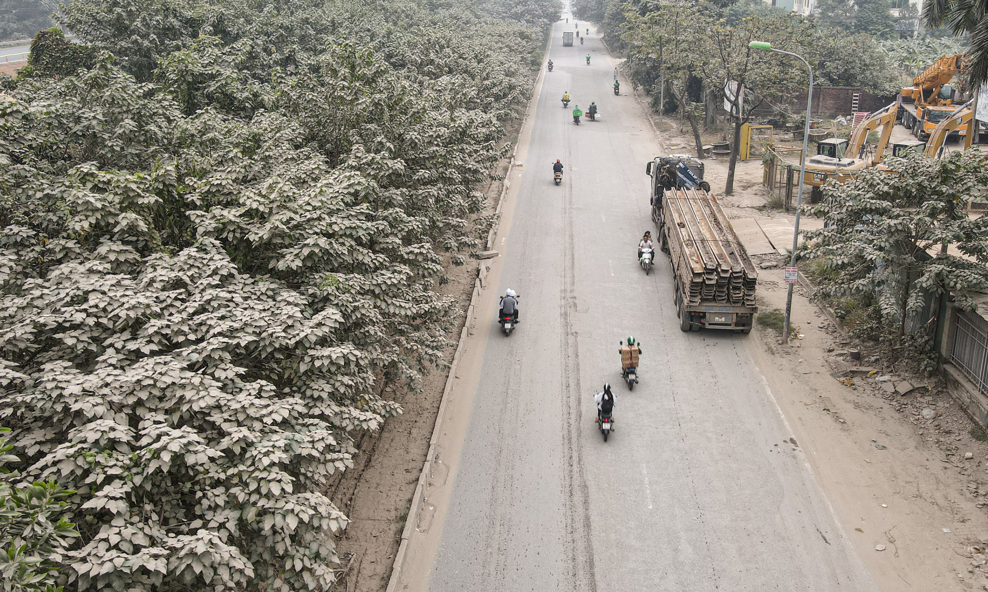 'Bão bụi' bao phủ đường cửa ngõ Hà Nội, cây cối chuyển màu trắng xóa