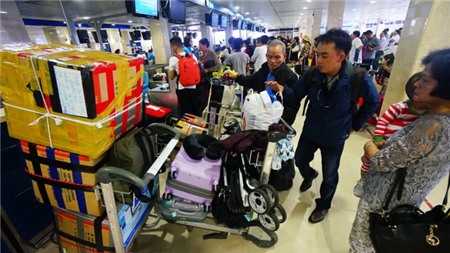 Sân bay Tân Sơn Nhất dịp tết hay quá tải là không tránh khỏi. Nhiều hãng hàng không có nguy cơ không được cấp phép tăng chuyến dù đã bán vé. Trong ảnh: hành khách làm thủ tục lên máy bay tại sân bay Tân Sơn Nhất - Ảnh: Quang Định