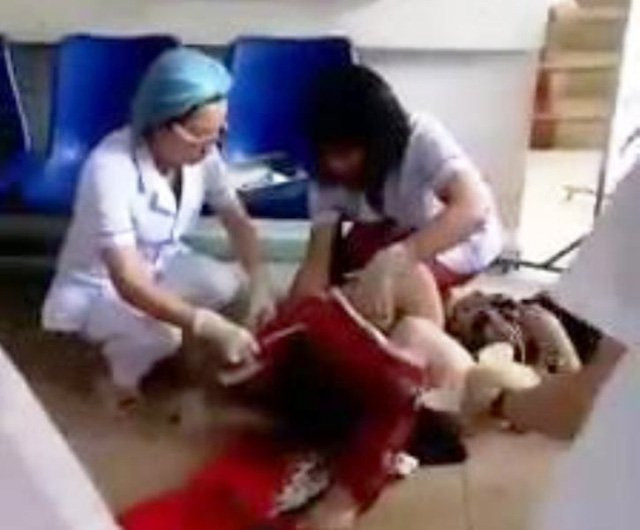 Các bác sĩ Khoa Sản, BVĐK Hòa Bình đỡ đẻ cho sản phụ T ngay tại chân cầu thang tầng 1 của bệnh viện (ảnh cắt từ clip)