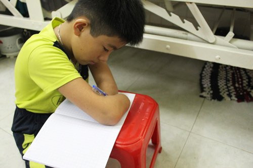 Em Nguyễn Gia Lâm ở Tây Ninh bị khuyệt tật tay chân, viết chữ bằng mỏm cụt. Ảnh: Cao Khẩm.