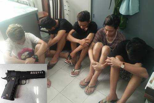 Những nghi can bị bắt và khẩu súng bắn bi sắt thu được của nhóm đối phương. Ảnh: Quốc Thắng.