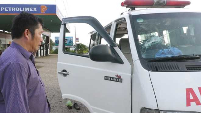 Ông Tuấn và chiếc xe cấp cứu với nhiều vết chém, đập do bị ngăn không cho vào chở bệnh nhân