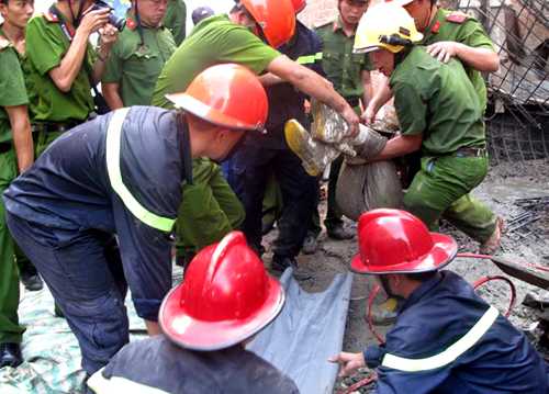 Sau một giờ cắt bêtông và sắt thép, cảnh sát cứu hộ đưa nạn nhân bị vùi lấp ra ngoài. Ảnh: A.X