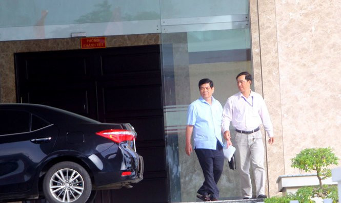 Ông Nguyễn Phong Quang (áo xanh, bên trái) bước ra cổng Ban Chỉ đạo Tây Nam bộ sau buổi họp triển khai kết luận của Ủy ban Kiểm tra trung ương chiều 22-8 - Ảnh: CHÍ QUỐC