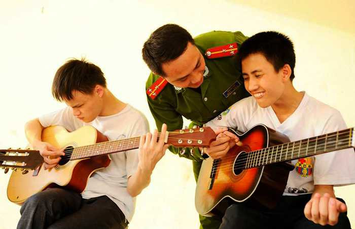 Hinh anh Nguong mo thay giao cong an day guitar cho tre em khiem thi