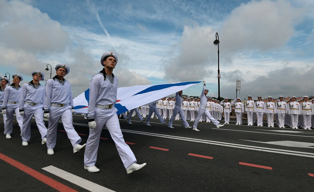 Các thủy thủ rước một lá cờ của Hải quân Nga trong lễ duyệt binh. (Ảnh: RIA Novosti)