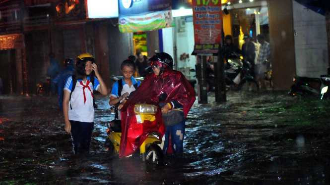 Phụ huynh và học sinh lội nước về nhà - Ảnh: A LỘC