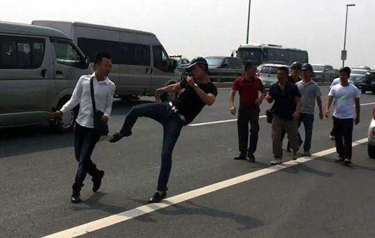 Ngày 23/9, trong lúc tác nghiệp vụ tài xế taxi nghi nhảy cầu Nhật Tân tự tử, phóng viên Quang Thế - báo Tuổi trẻ TPHCM - bị một số người mặc thường phục cản trở, hành hung. Sau đó, công an huyện Đông Anh (TP Hà Nội) thừa nhận một số người hành hung Quang Thế là cán bộ Công an huyện này. (Ảnh: Nguyễn Dương)