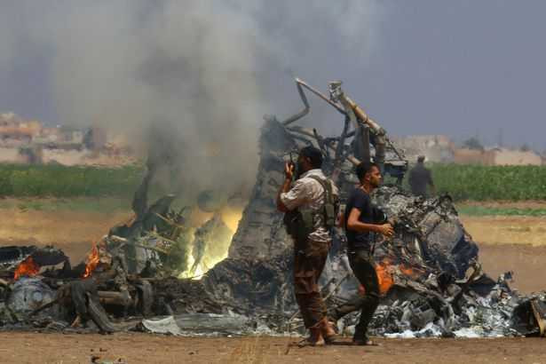 men-inspect-the-wreckage-of-a-russian-helicopter-that-had-been-shot-down-in-the-north-of-syrias-reb-2151