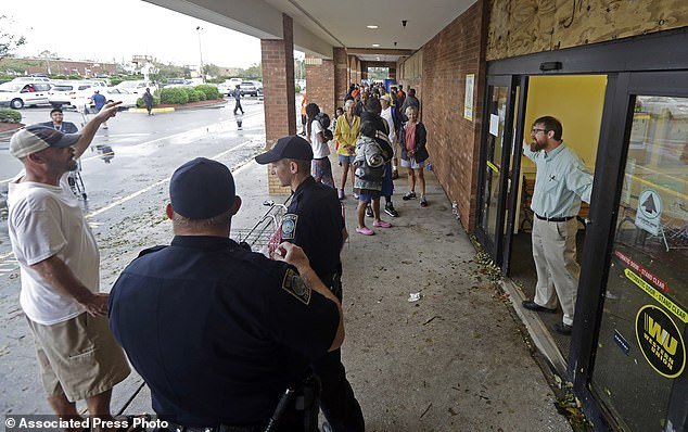 4322534-6173681-Wilmington_police_stand_guard_as_a_Lowe_s_Foods_employee_stands_-a-3_1537127168128