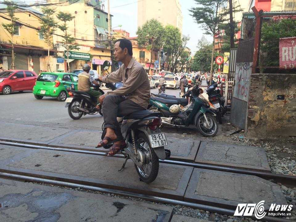 6- Bac xe ôm ngang nhien ngoi giua hai duong ray tau doi khach