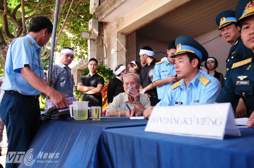 Ông Phùng, bố đẻ của anh Khải ngồi tại bàn viếng trước khi linh cữu anh được chuyển về - Ảnh: Tùng Đinh