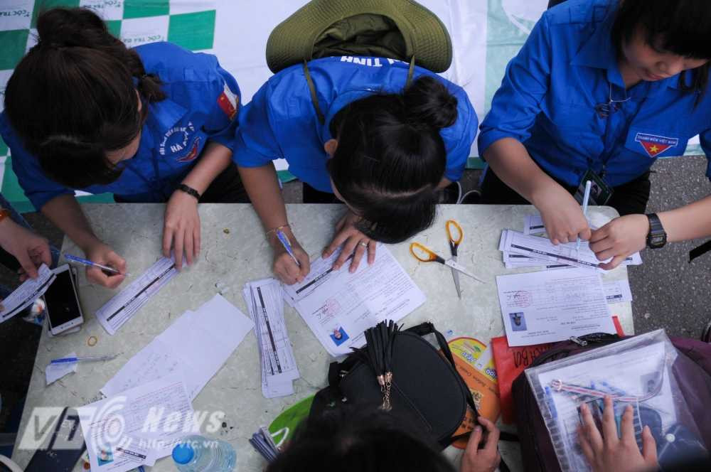 Sinh viên tình nguyên giúp thí sinh đăng ký gửi đồ - Ảnh: Tùng Đinh