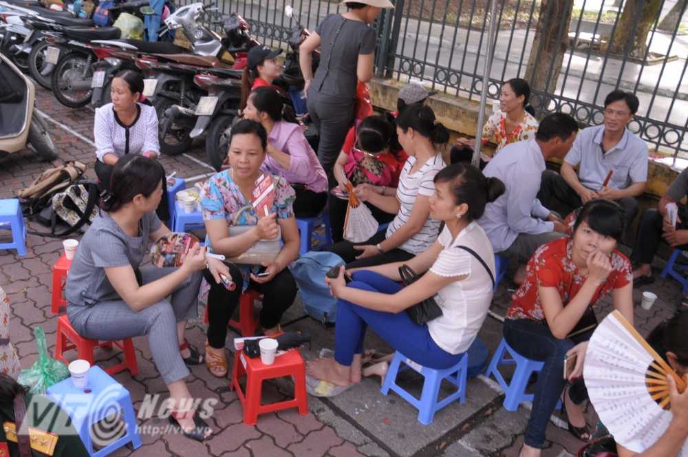 Nhiều phụ huynh cho rằng, về nhà cũng không yên tâm nên ngồi đợi luôn ngay tại địa điểm thi - Ảnh: Tùng Đinh