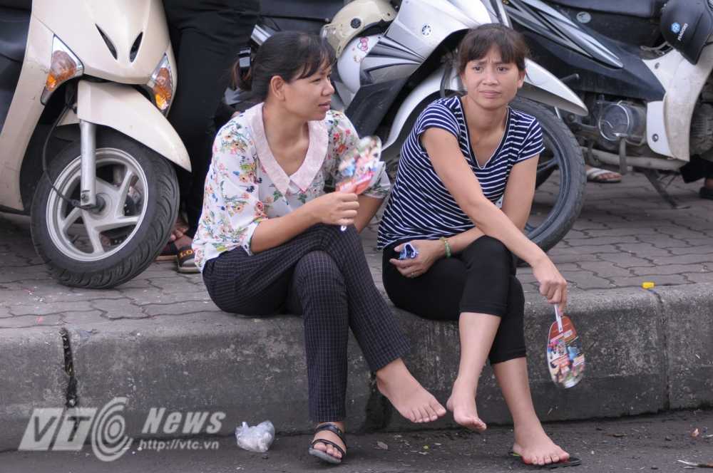 Nhiều người chọn ngay vỉa hè, trước các trường thi để nghỉ ngơi - Ảnh: Tùng Đinh
