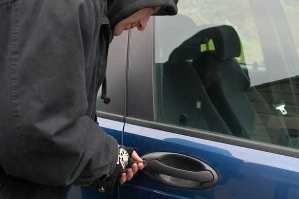 Car-thief-using-a-screwdriver-to-brake-into-a-car