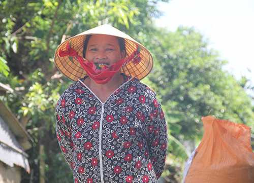 Bà Quế tranh thủ chở lúa về nhà để đón khách tới chia vui thành tích của con trai. Ảnh: Đức Hùng