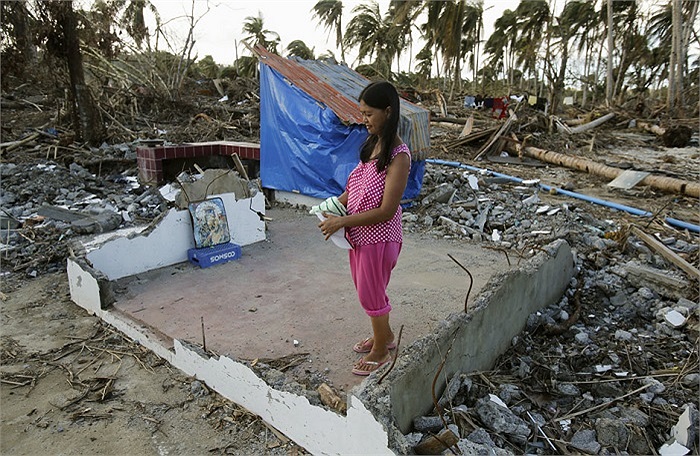 Một người phụ nữ Philippines đứng tại phòng khách căn nhà bị phá hủy do siêu bão Hải Yến