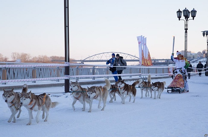 Mikhail Fateyev cầm ngọn ngọn đuốc Olympic trên bờ kè sông Tura trong cuộc rước đuốc Olympic tại Tyumen, tây Siberia, Nga