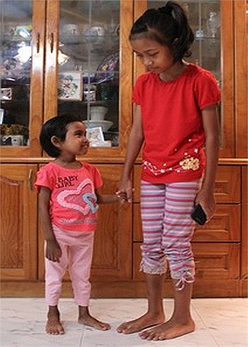 Syarah Insyirah Sulaiman (trái), ngụ tại Singapore, vốn là một em bé 8 tuổi nhưng đang mắc căn bệnh lạ, khiến cơ thể em trông như trẻ lên 3.