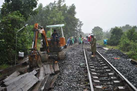 Dù trời mưa to nhưng công nhân đường sắt vẫn đang khắc phục lại những đoạn đường bị mưa lũ làm xói lở ở xã Canh Vinh. (ẢNH - ĐÌNH PHÙNG)