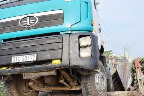 Khi tài xế đang cho xe đầu kéo chở máy ép cọc bêtông có trọng lượng 60 tấn băng qua cây cầu sắt ở Vĩnh Long thì cầu gãy đôi, đuôi xe rơi xuống sông.