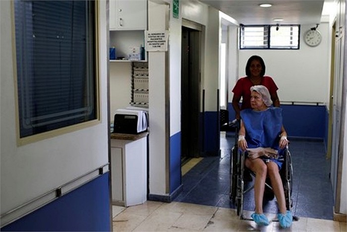 Chị Parejo được một y tá đẩy xe lăn vào trong phòng phẫu thuật.