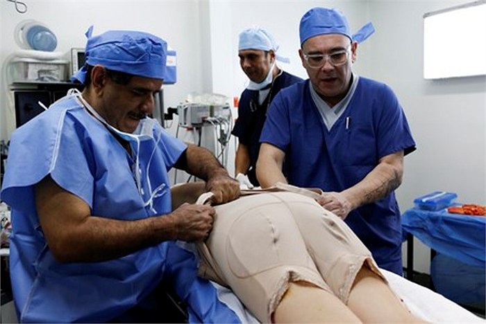 Các bác sỹ mặc lại chiếc áo nịt ngực cho bệnh nhân sau phẫu thuật.