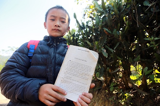 Vi Văn Huy với cuốn truyện nhặt được trên tay. Huy cho biết em rất thích cuốn truyện 'Người con út hiếu thảo' 