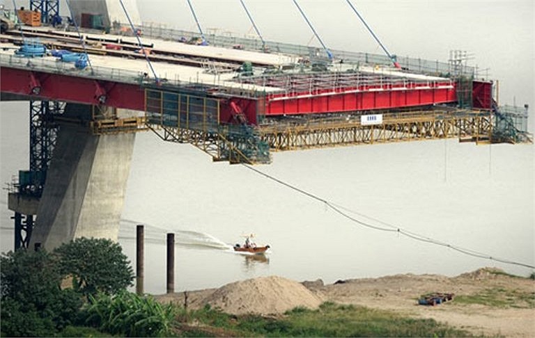 Tại cả 5 trụ tháp chưa được nối liền với đường dẫn nằm giữa dòng, công nhân được đưa đón bằng ca nô qua lại hàng ngày để làm việc. 