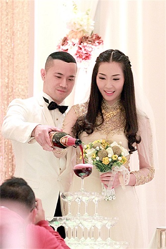 Cô cùng chồng cùng rót rượu mừng.