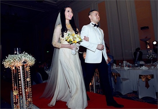 Á hậu Việt Nam 2010 rạng rỡ theo chồng tiến vào khán phòng tổ chức tiệc cưới. 