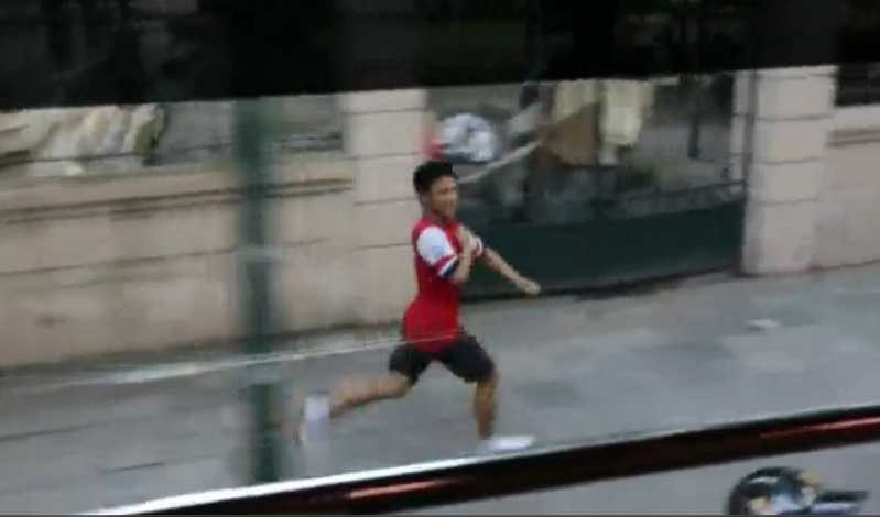 Hành động chạy theo xe bus chở các cầu thủ Arsenal chiều 16/7 của CĐV Vũ Xuân Tiến đã gây tiếng vang không chỉ với người hâm mộ bóng đá Việt Nam mà trên toàn thế giới. Ảnh chụp từ clip.