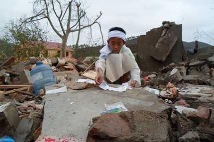 Cậu bé Phan Ngọc Trung (12 tuổi, xã Quảng Sơn, Quảng Trạch, Quảng Bình) bỗng mồ côi cha sau trận bão lũ kinh hoàng, đang lần tìm từng quyển sách ướt cho ngày mai tới trường.