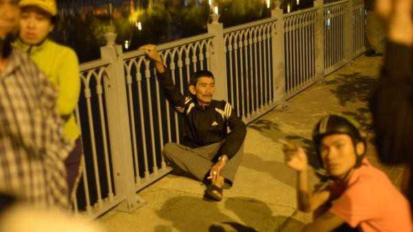  Sau hơn 3h tìm kiếm, thi thể anh Phát được tìm thấy ngay khu vực gần trụ cầu Điện Biên Phủ vào lúc 3h30. Một giờ sau thì thi thể chị Duyên cũng được lực lượng chức năng tìm thấy cách trụ cầu khoảng 30m. Được biết, vợ chồng anh Phát vừa mới cưới nhau khoảng một tháng nay. Ảnh: Cha của nạn nhân nam bần thần chờ tin con.