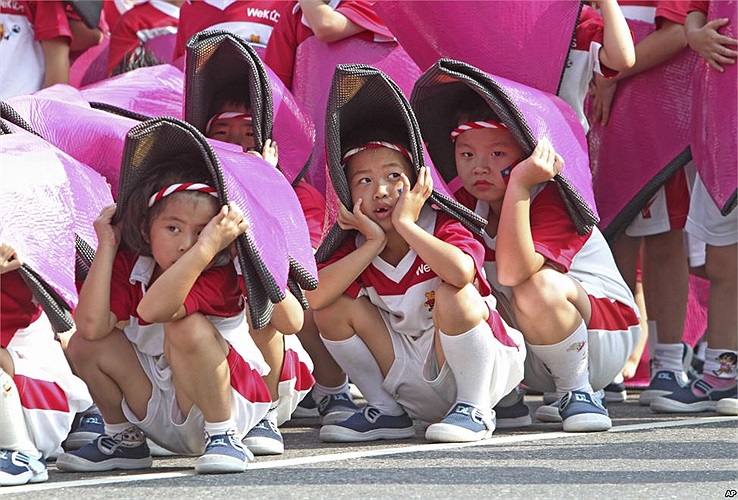 Trẻ em Đài Loan ngồi chịu nắng trong buổi diễn tập để kỷ niệm ‘Ngày Quốc gia’ (10/10 hàng năm) tại văn phòng chính phủ ở Đài Bắc