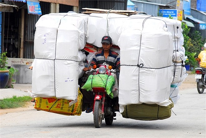Người đàn ông Campuchia chở hàng hóa cồng kềnh trên chiếc xe máy từ cửa khẩu Tịnh Biên đi về Campuchia.