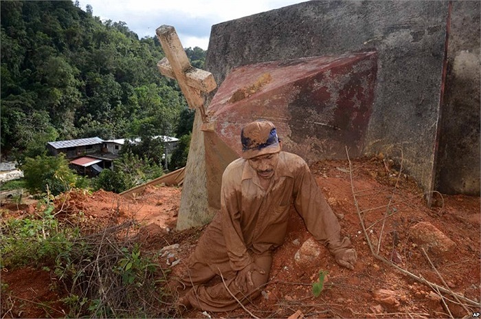 Một người đàn ông ở La Pintada, Mexico đang ngồi nghỉ sau khi cố gắng tìm xác vợ và hai đứa con sau một trận lở đất