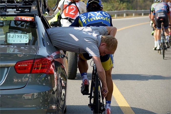Một nhân viên sửa xe cho tay đua xe đạp ngay trên đường đua Tour of Beijing 2013 tại Trung Quốc