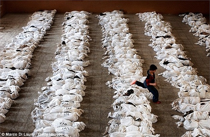 Một cậu bé nhảy qua các phần thi thể còn sót lại được tìm thấy trong một ngôi mộ tập thể ở phía nam thủ đô Baghdad.