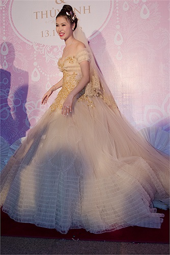 Chiếc váy cưới trễ vai màu vàng đồng được cô dâu Thủy Anh mặc khi tổ chức hôn lễ tại khách sạn là một mẫu trong bộ sưu tập Giấc mơ hoa.