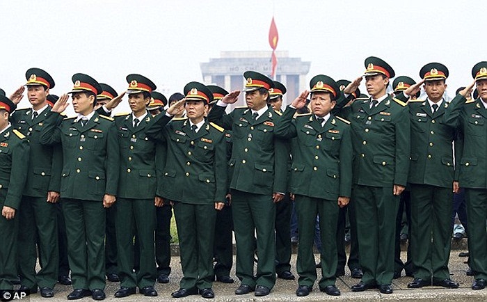 Các sĩ quan Quân đội nhân dân Việt Nam giơ tay chào theo nghi thức khi linh xa đi ngang qua