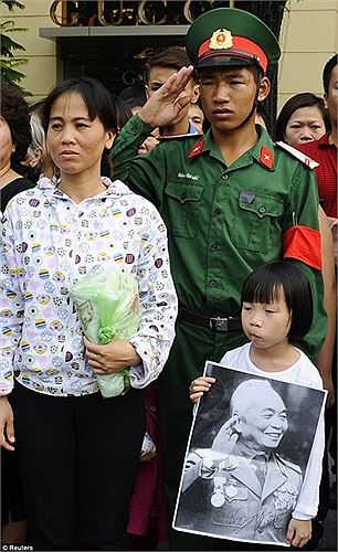 Cô bé mang di ảnh của Đại tướng và chàng chiến sĩ trẻ đưa tay chào tiễn đưa Đại tướng