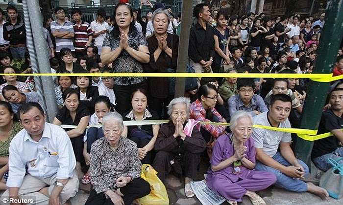 Người dân chắp tay cầu khấn khi linh xa đi ngang qua, trên đường đến sân bay Nội Bài