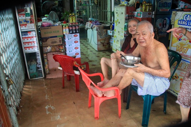 Dân Sài Gòn dùng máy bơm hút nước ra khỏi nhà-19Cụ ông bắt ghế cao, ngồi ăn sáng. Ảnh: ĐS& PL