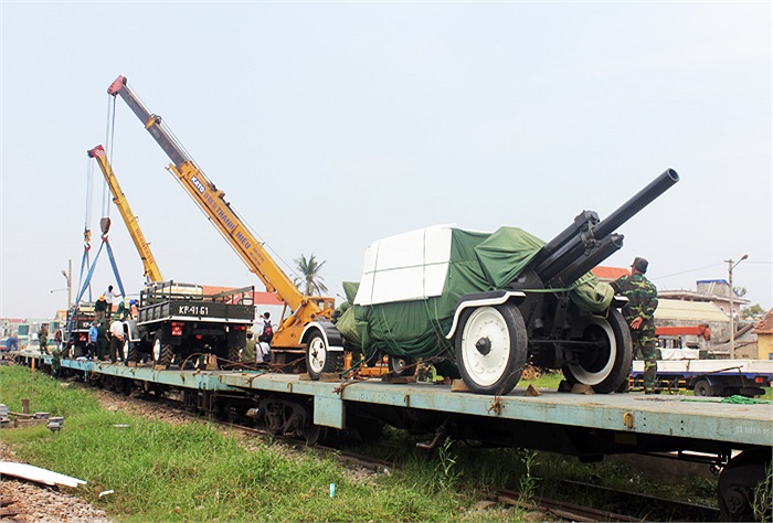 Hai xe cẩu bốc dỡ xe và pháo xuống.